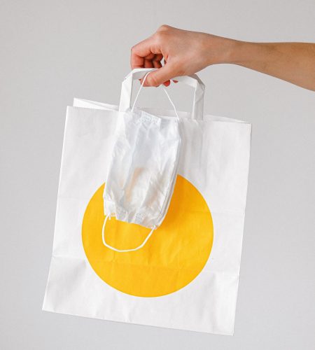 person-holding-paper-bag-and-face-mask-3987245